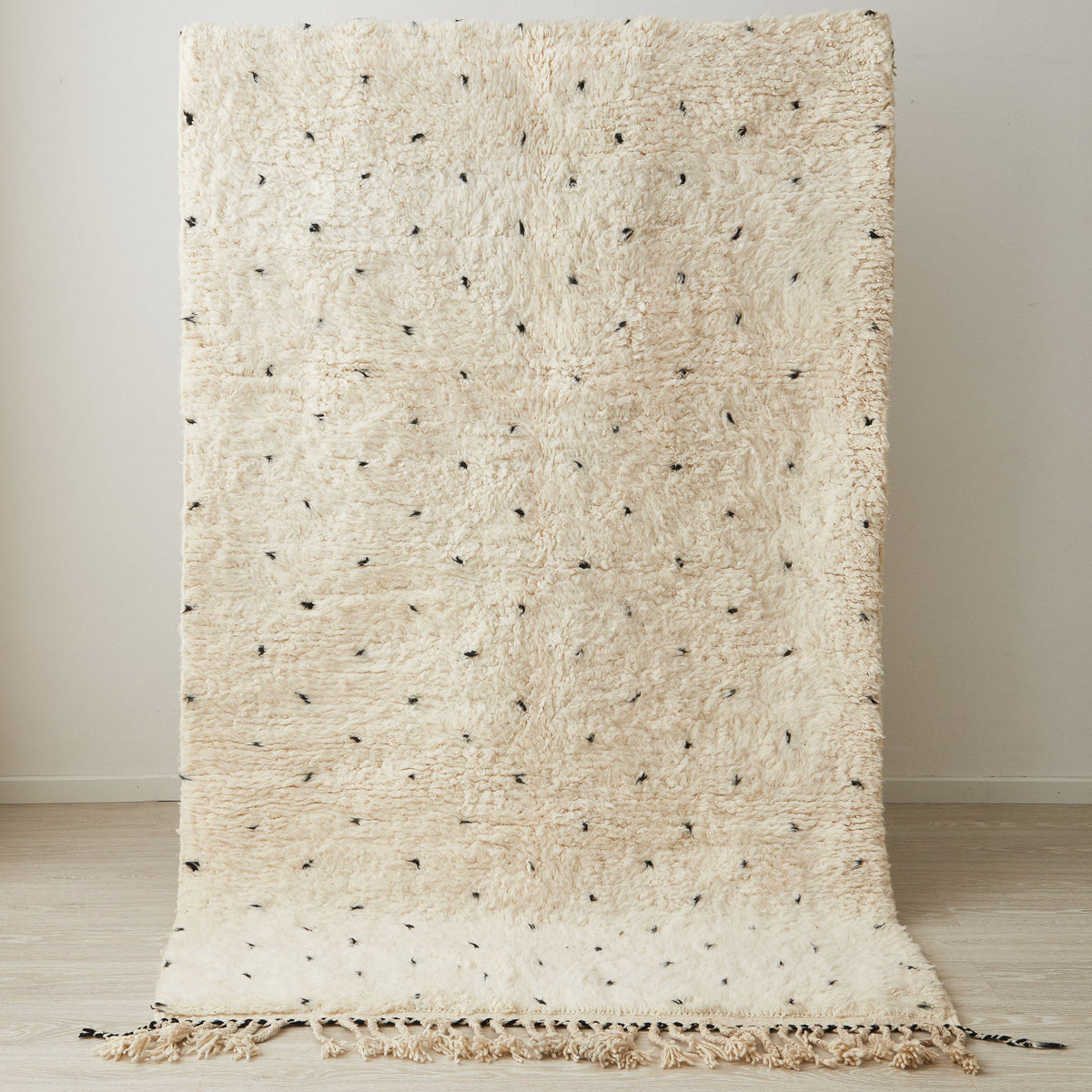 tappeto beni ourain con morbido pelo lungo pois neri e frangia bianca e nera posizionato in verticale