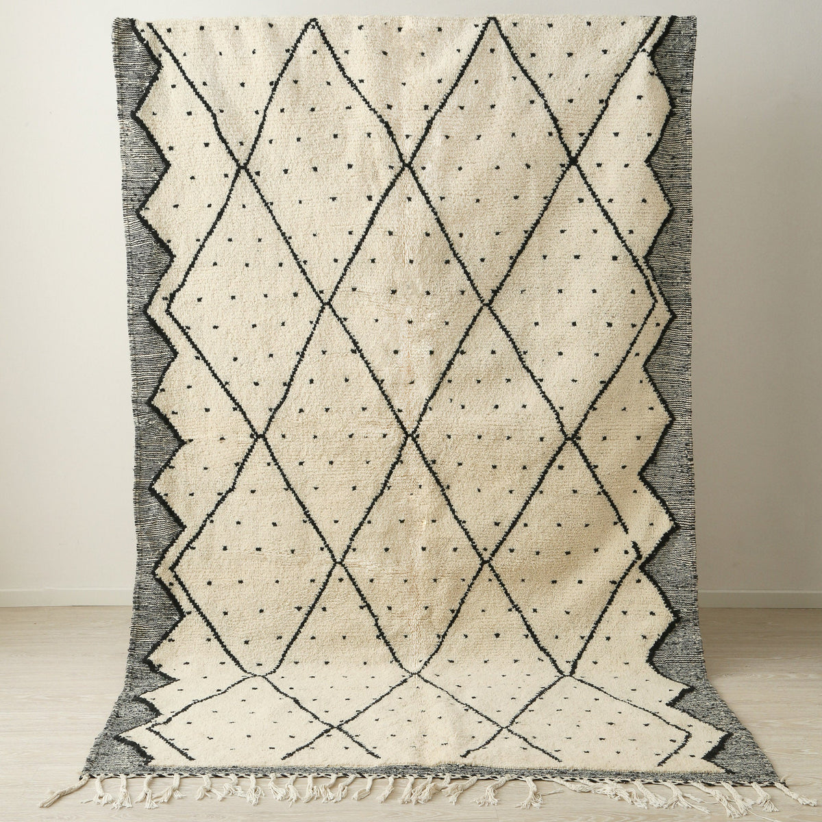 tappeto beni ourain con disegni geometrici a rombi e pois neri  e lati scuri posizionato in verticale