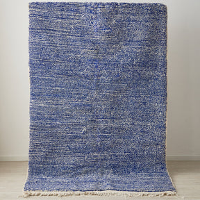 tappeto beni ourain a tinta unita con colore blu melange  e frange bianche posizionato in verticale