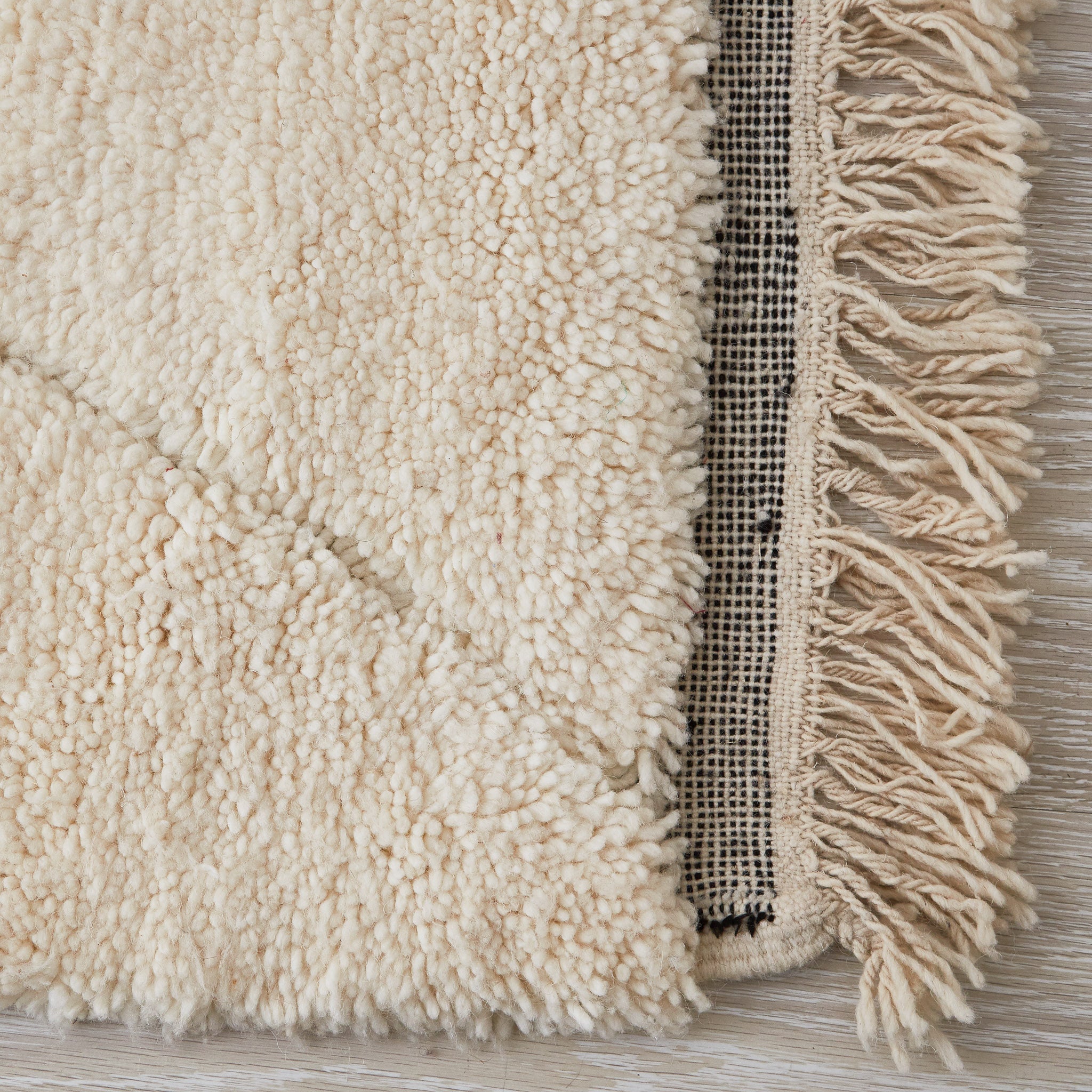 tappeto beni ourain con morbido pelo lungo a tinta unita e disegni geometrici con leggera rasatura dettaglio frangia e lato corto nero