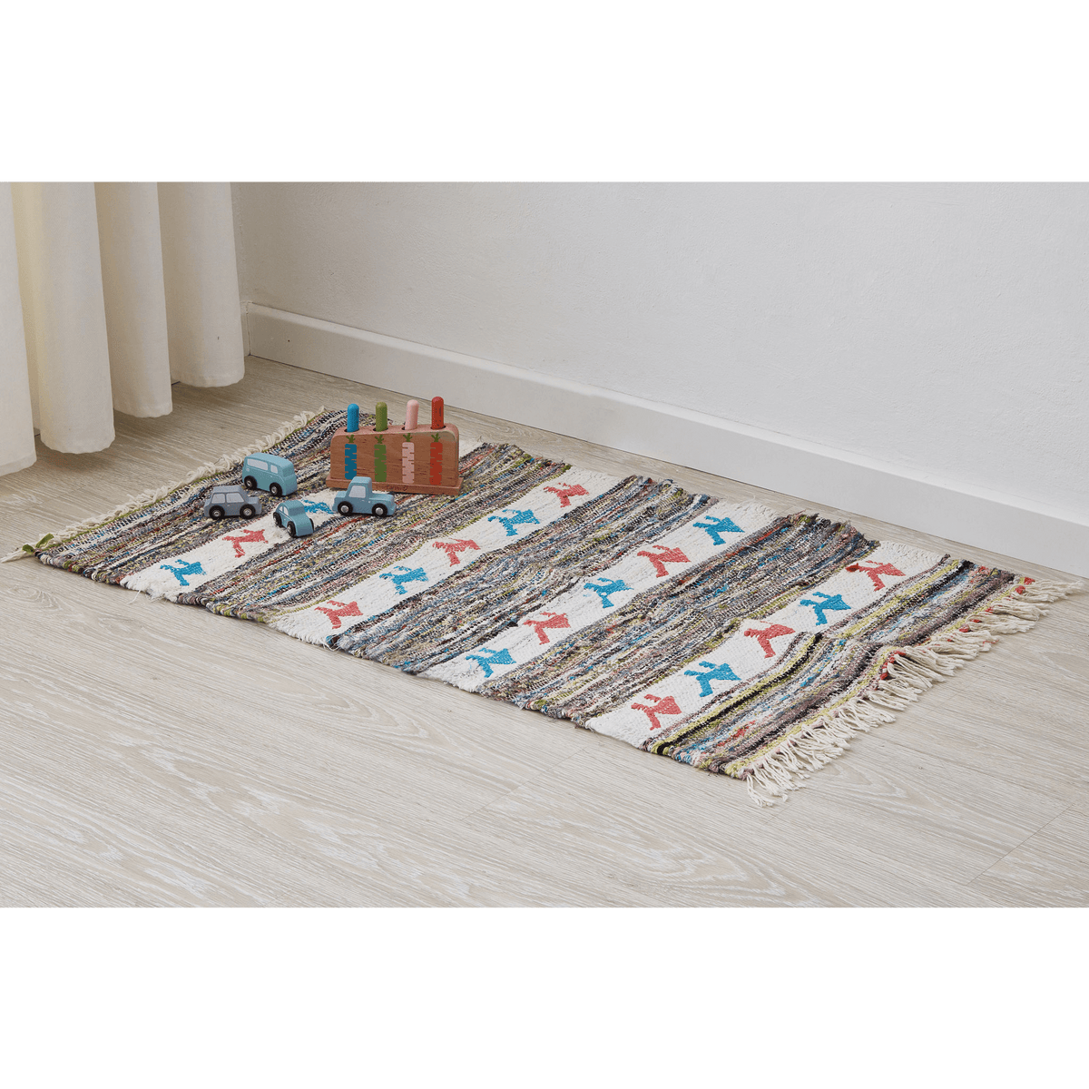 piccolo tappeto a tessitura piatta con cammelli rosa e azzurra disteso sul pavimento