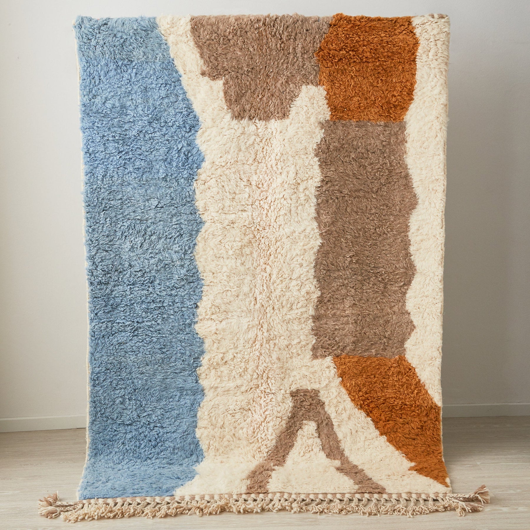 tappeto contemporaneo colorato su base bianca a pelo lungo e doppia frangia posizionato in verticale