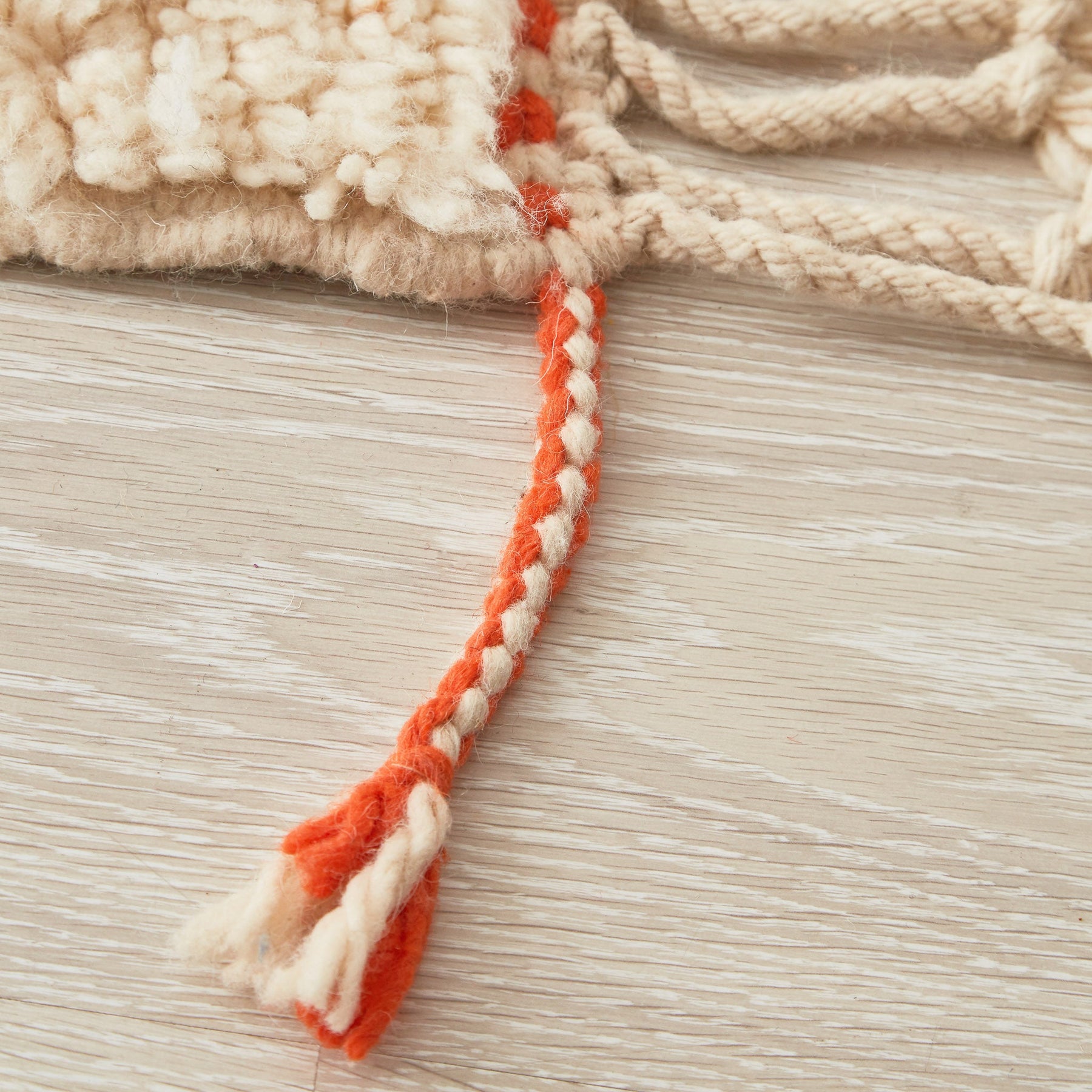 tappeto contemporaneo grande con 3 forme geometriche di diversi colori su base bianca e doppia frangia dettaglio di una frangia bianca e arancione