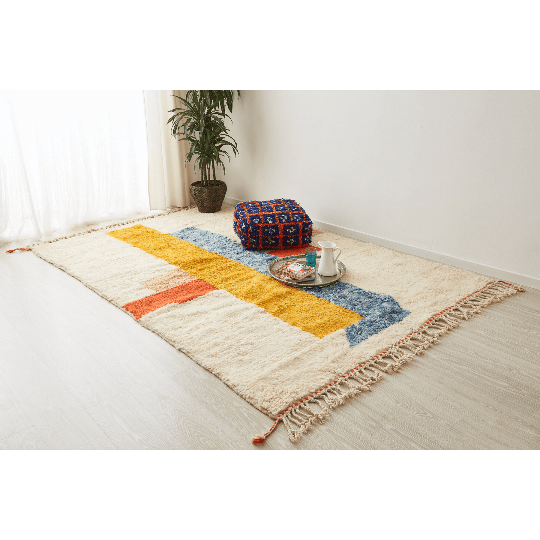 tappeto contemporaneo grande con 3 forme geometriche di diversi colori su base bianca e doppia frangia disteso sul pavimento