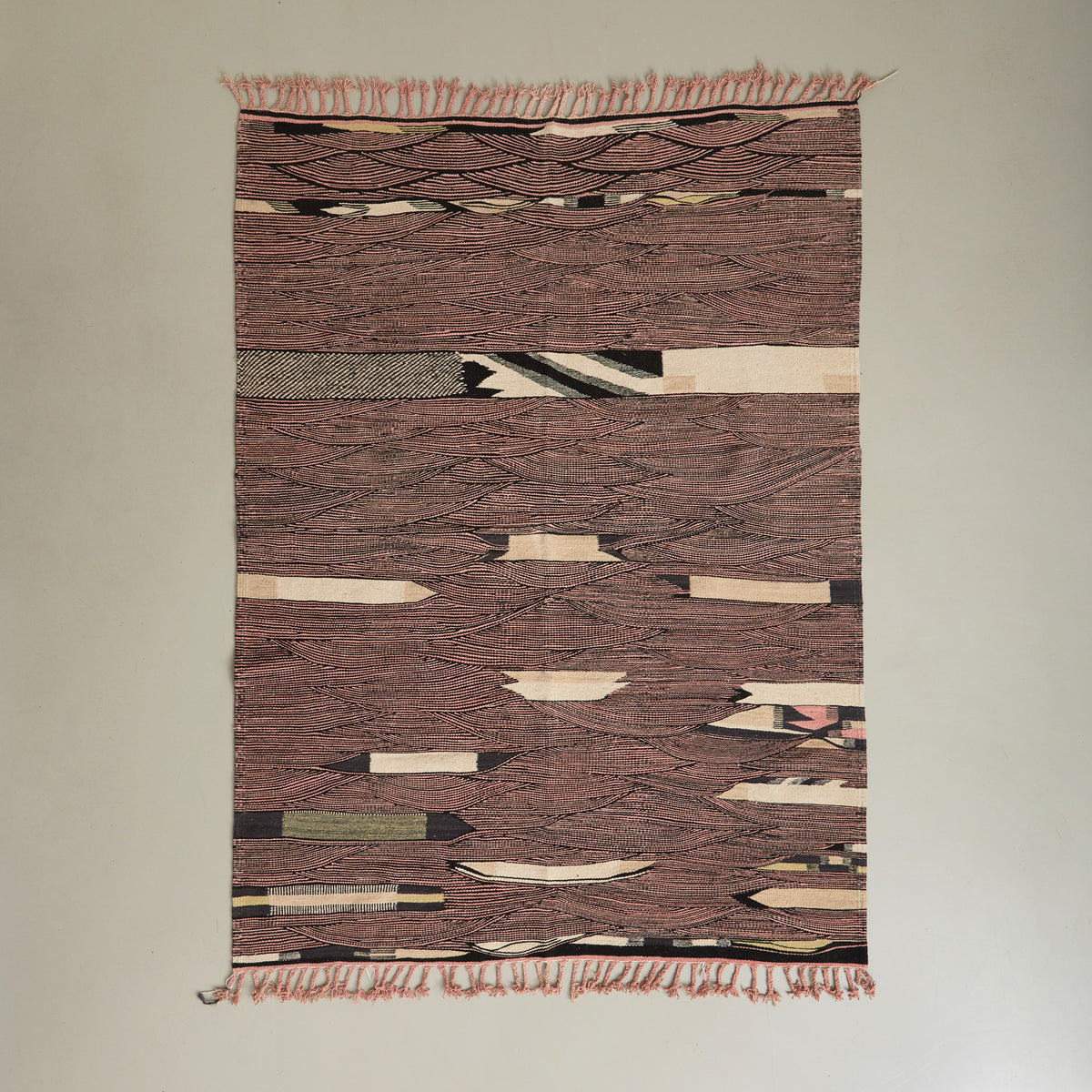 tappeto kharita a tessitura piatta realizzato intrecciando lana nera e rosa disteso