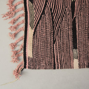 dettaglio della frangia rosa e della lavorazione di un tappeto kharita a tessitura piatta realizzando intrecciando lana nera e rosa 