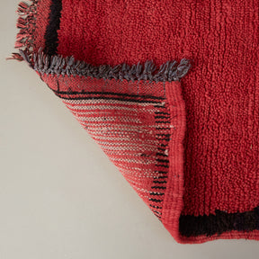 dettaglio del retro di un tappeto azilal vintage per corridoio in lana rossa con bordo nero