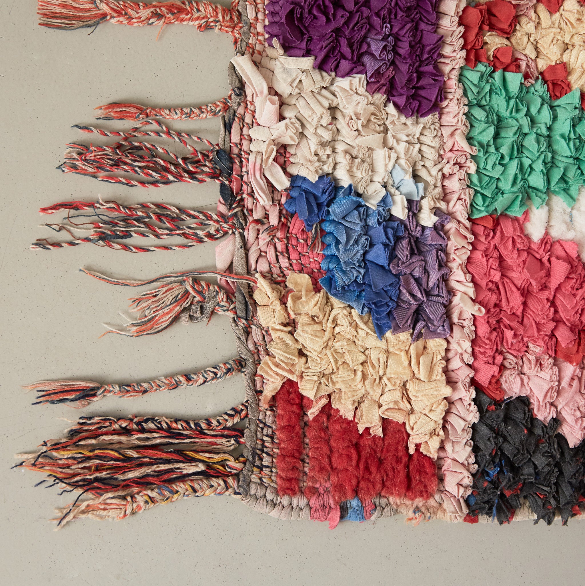dettaglio della frangia e delle fettuccie di tessuti annodati di un tappeto boucherouite vintage