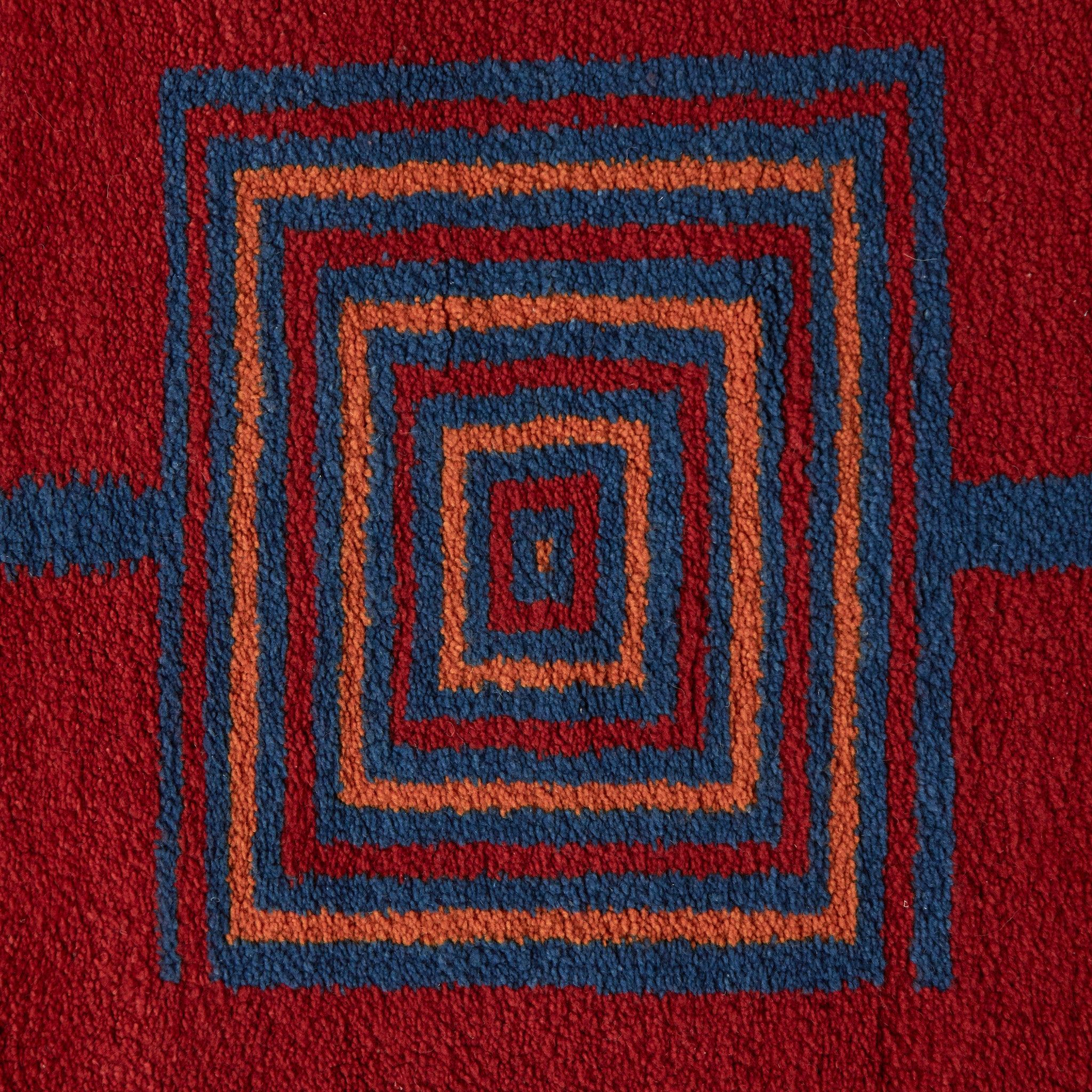 disegno geometrico blue e arancione su base rossa di un tappeto taznakht piccolo realizzato con lana siroua tinta con colori naturali su base rossa e disegni geometrici