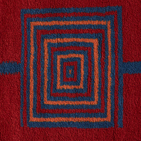 disegno geometrico blue e arancione su base rossa di un tappeto taznakht piccolo realizzato con lana siroua tinta con colori naturali su base rossa e disegni geometrici