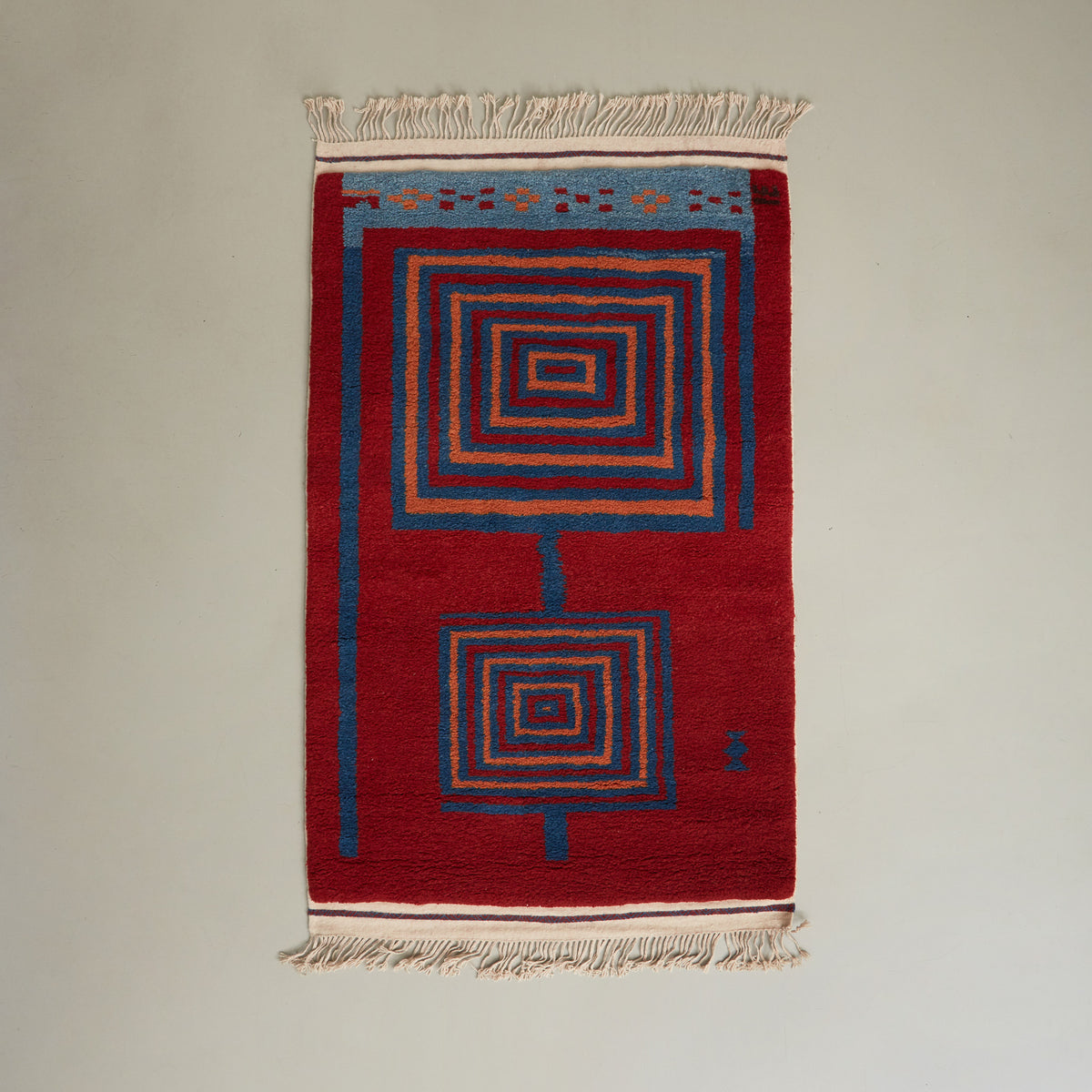 tappeto taznakht piccolo realizzato con lana siroua tinta con colori naturali su base rossa e disegni geometrici disteso su pavimento