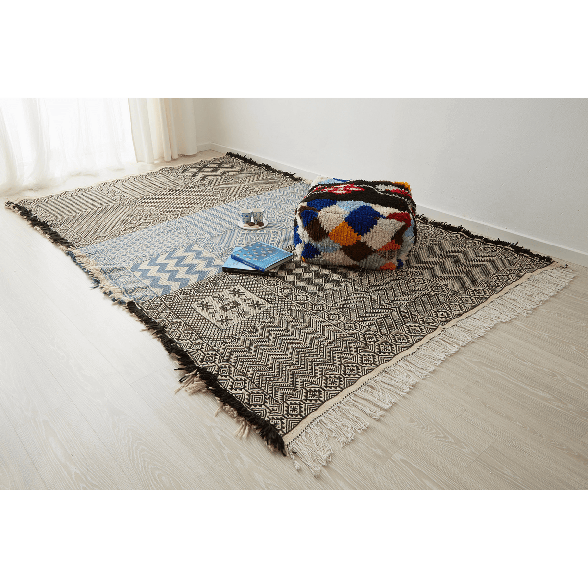 tappeto zanafi taznakht grande a tessitura piatta bianco nero e azzurro con frange su tre lati disteso sul pavimento
