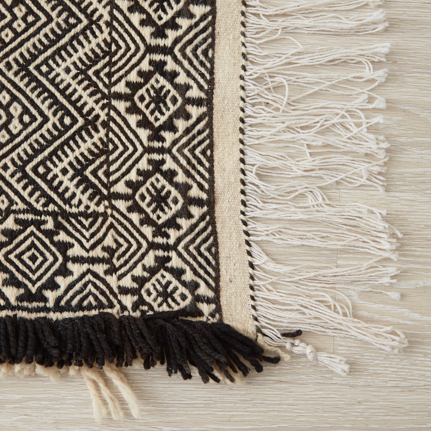 tappeto zanafi taznakht grande a tessitura piatta bianco nero e azzurro con frange su tre lati dettaglio di un angolo