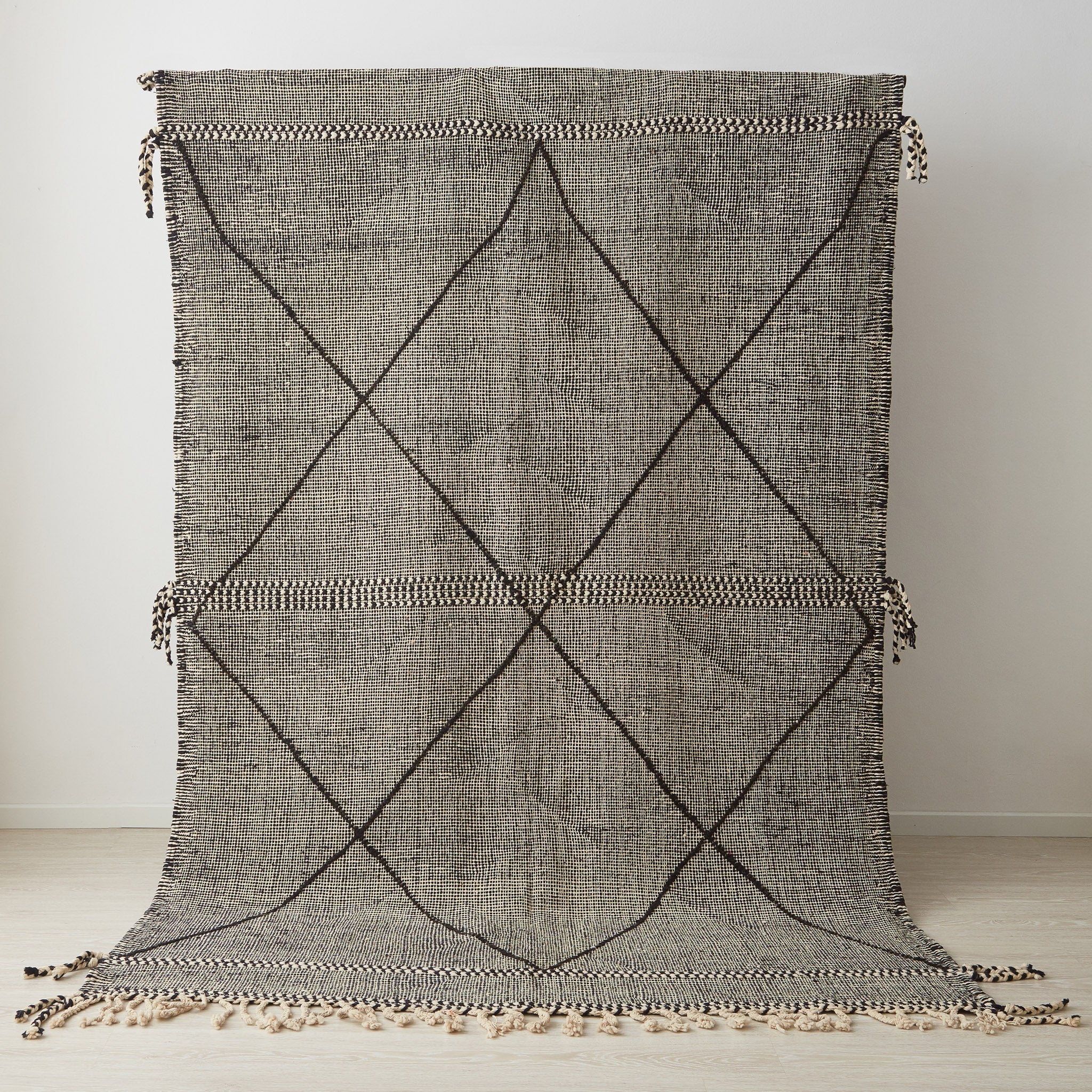 tappeto zanafi a tessitura piatta con frange su tutti i lati bianco e nero con decorazioni geometriche messo in posizione verticale
